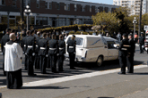 Members stand at attention following hearse